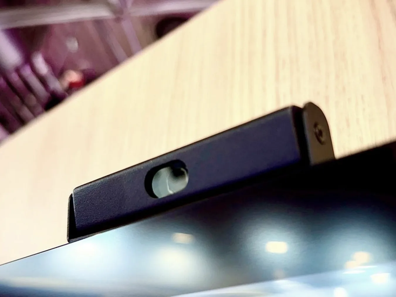 Slim camera clipped to the top of a display